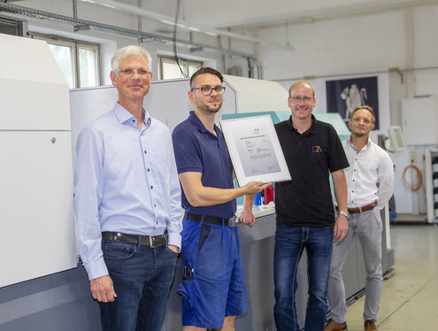 Erik Scharf (2. v. r.) und Marco Kraegen präsentieren die Urkunde für die Zertifizierung des Digitaldrucks zusammen mit Peer-Philipp Keller (alle DZA) und Hans-Georg Deicke (SID, links)